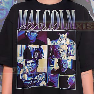 May include: Black crew neck t-shirt with a graphic of Malcolm McDowell. The graphic includes multiple images of the actor and the name "Malcolm McDowell" in a purple and white font.