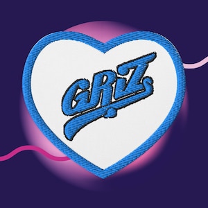May include: Blue and white heart-shaped patch with the word "CRUZ" embroidered in a blue cursive font.