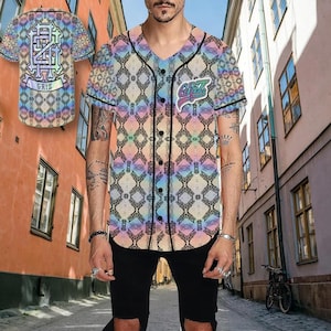 Könnte beinhalten: Ein Baseball-Trikot mit einem farbenfrohen geometrischen Muster in Pastelltönen von Rosa, Blau und Gelb. Das Trikot hat schwarze Verzierungen, eine Knopfleiste und das Wort "GRIZ" auf der Vorder- und Rückseite.