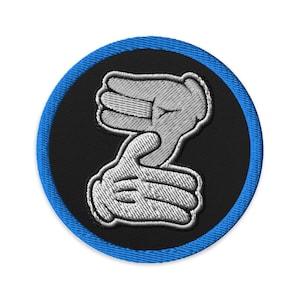 Può includere: Toppa rotonda ricamata con sfondo nero e bordo blu. Presenta due mani bianche con guanti in stile cartoon che formano una 'Z'. Ideale per abbigliamento o accessori.