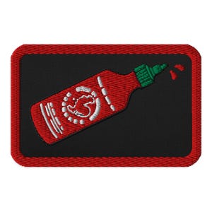 May include: Red and white hot sauce bottle with a green lid and a rooster logo. The bottle is pouring out a drop of sauce. The image is on a black background with a red border.