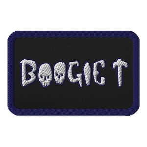 May include: A black embroidered patch with a white outline and the text "Boogie T" in a stylised font. The text is surrounded by two skull designs.