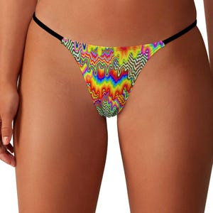 May include: A colorful thong with a psychedelic, wavy pattern in shades of red, orange, yellow, green, blue, and purple. The thong has a black string waistband and is made of a soft, stretchy material.