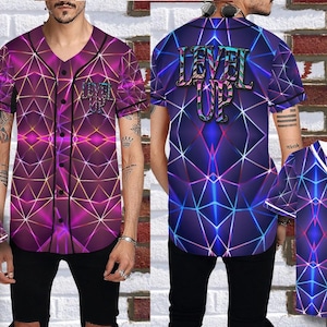 Puede incluir: Camiseta de b&eacute;isbol con un dise&ntilde;o geom&eacute;trico en tonos morados, rosas y azules. La parte delantera presenta el texto "LEVEL UP" y la trasera el mismo texto. La camiseta tiene cierre de botones y mangas cortas.