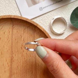 May include: Two silver rings with a hammered finish. The rings are simple and elegant, and would make a great gift for a friend or loved one.