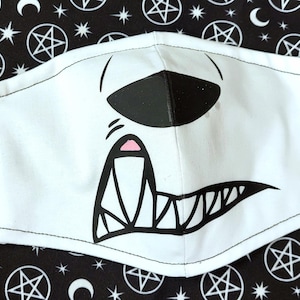 May include: White face mask with a black and white cartoon illustration of a snarling monster with sharp teeth and a pink nose.