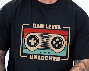 Camiseta desbloqueada com nível de pai, cores confortáveis, camiseta retrô para jogos, presente de dia dos pais para pais jogadores e amantes de videogame, anúncio de gravidez