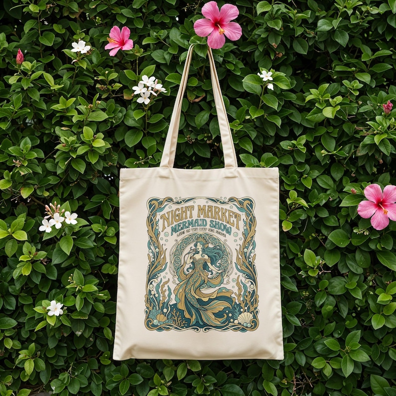 Cream tote bag with "Night Market Mermaid Show" text and sea-themed illustration.