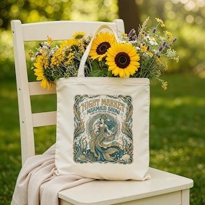 Tote bag with "Night Market Mermaid Show" design featuring a mermaid and sunflowers.
