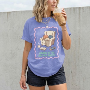 May include: A white ceramic mug with a black handle and the text "But First, Coffee" in a handwritten style. The mug is on a white surface. The mug is approximately 4 inches tall.