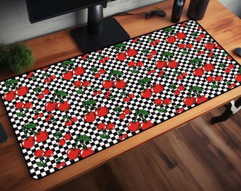 Può includere: Un tappetino da scrivania rettangolare con un motivo a scacchi bianchi e neri con ciliegie rosse e foglie verdi. Il tappetino è progettato per proteggere la superficie della scrivania e fornire un'area liscia per mouse e tastiera.