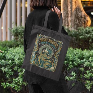 Black tote bag with "Night Market Mermaid Show" design featuring a mermaid and sea elements.