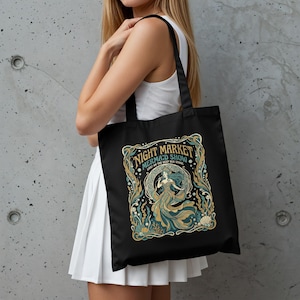 Black tote bag with a mermaid, coral, and sea-themed design.