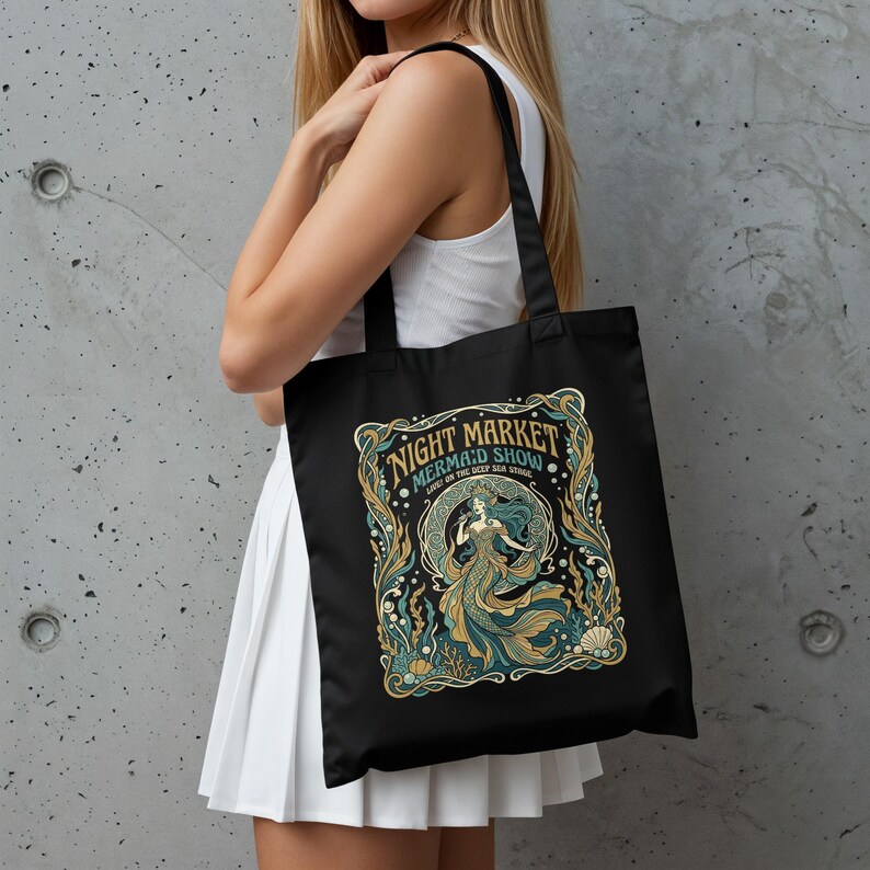 Black tote bag with a mermaid, coral, and sea-themed design.