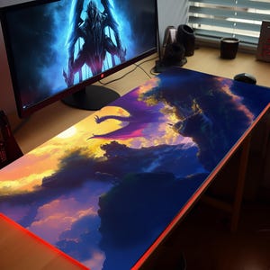 a desk with a computer monitor and a large painting on it