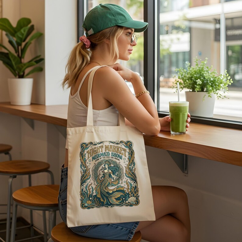 Canvas tote bag with "Night Market Mermaid Show" text and elaborate mermaid design.