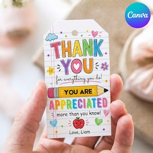 Op de afbeelding: Een wit cadeaulabel met de woorden "THANK YOU" in kleurrijke blokletters. Het label bevat de zinnen "for everything you do!" en "YOU ARE APPRECIATED more than you know!" Er is ook een potloodafbeelding aanwezig, samen met een appel en de naam "Love, Liam".