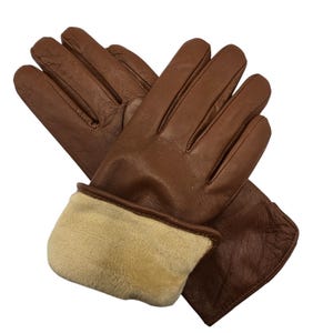 May include: A pair of brown leather gloves with a fleece lining. The gloves have a fold-over cuff.