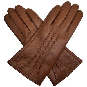 May include: A pair of brown leather gloves with a stitched design. The gloves are folded in half and the stitching is visible on the back of the gloves.