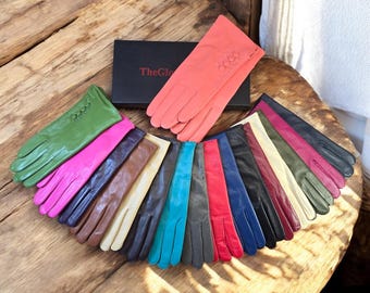 Peut inclure: Une collection de 14 paires de gants en cuir de différentes couleurs, notamment vert, rose, marron, beige, bleu, turquoise, rouge et noir. Les gants ont un détail boutonné au poignet.