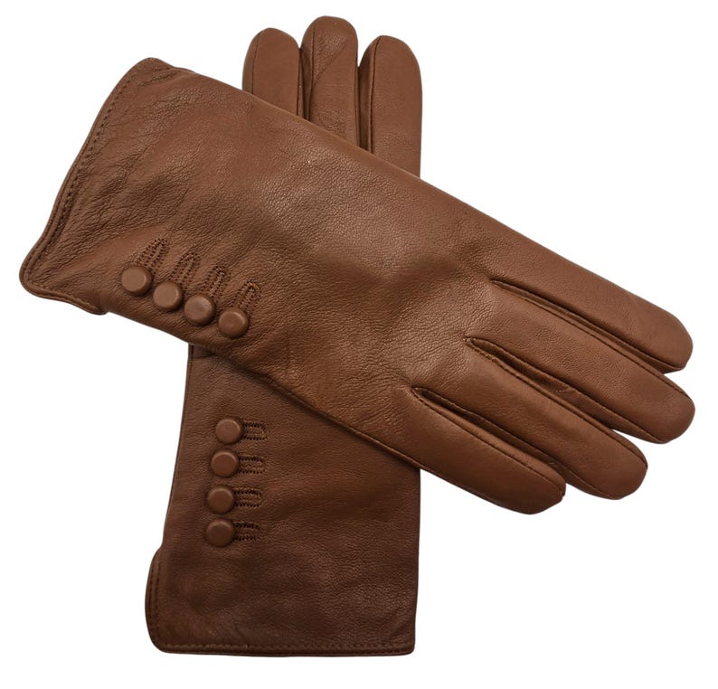 May include: A pair of brown leather gloves with button detailing on the cuff.