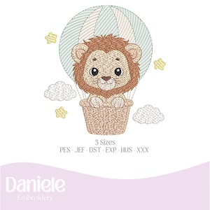 Pode incluir: Design bordado com um filhote de leão em um balão de ar quente. O balão tem listras verdes e brancas, e o leão está em uma cesta tecida. O design inclui nuvens e estrelas bordadas. O texto "5 Sizes" é visível.