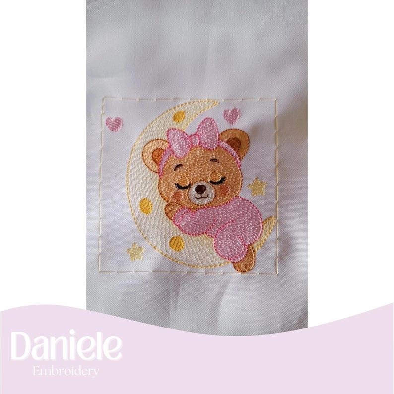 May include: Embroidered design of a sleeping teddy bear on a crescent moon, wearing a pink bow and outfit. The design includes yellow stars and pink hearts, all on a white background. The text "Daniele Embroidery" is at the bottom.