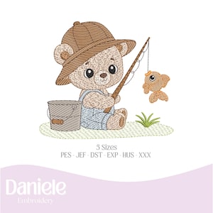 May include: Embroidered design of a brown bear wearing a brown hat and overalls, holding a fishing rod with a small orange fish on the line. The bear is sitting on a green patch of grass with a brown bucket beside it.