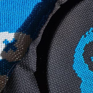 Może przedstawiać: Zbliżenie na dwa wzory haftu krzyżykowego w kolorze niebieskim i białym. Jeden wzór jest na czarnym materiale, a drugi na białym.