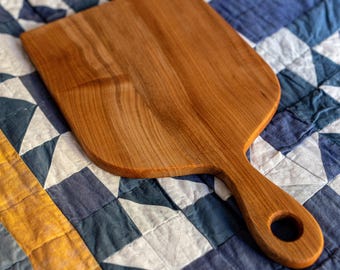 Handmade spalted maple cutting board with integrated handle showing dramatic natural grain patterns