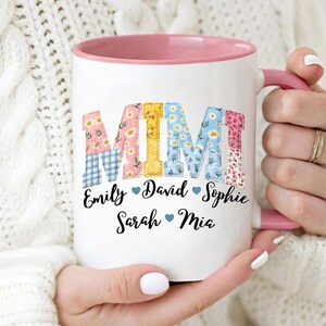 May include: White ceramic mug with a pink interior and handle. The mug features the word "MIMI" in colourful, patterned letters, with names below. A personalised gift for a grandmother.