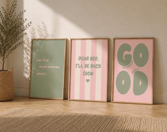 Op de afbeelding: Drie ingelijste wandposters. De eerste is saliegroen met de tekst "Just five more minutes, please...". De tweede heeft roze en witte verticale strepen met de tekst "DEAR BED, I'LL BE BACK SOON" en een hartje. De derde is roze met grote saliegroene letters die "GOOD" spellen en de woorden "MORNING" en "NIGHT".