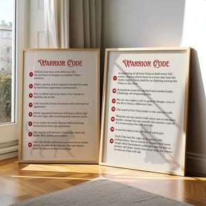 Op de afbeelding: Twee ingelijste prints met de tekst "Warrior Code" in een decoratief lettertype. De prints zitten in houten frames en leunen tegen een muur. De tekst is rood en de achtergrond is gebroken wit.