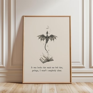 Könnte beinhalten: Gerahmter Kunstdruck mit einer schwarz-weißen Illustration eines Drachen über einem offenen Buch, mit Mond und Sternen. Der Text lautet: „Es waren Bücher, die mir das Gefühl gaben, dass ich vielleicht nicht ganz allein war.“