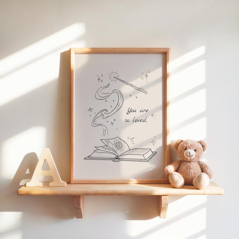 May include: A framed print with a whimsical illustration of a wand, stars, and an open book, with the text "You are so loved." A wooden letter "A" and a teddy bear sit on a wooden shelf.