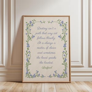 May include: A rectangular framed wall art print on a light beige background featuring a decorative border of green vines with small blue flowers. The text reads: Destiny isn't a path that any cat follows blindly. It is always a matter of choice and sometimes the heart speaks the loudest. -Leafpool