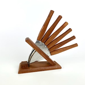 Könnte beinhalten: Ein Set aus drei Keramikbechern mit gesprenkelter, matter Oberfläche. Die Becher sind in Creme-, Hellgrau- und Dunkelgrautönen gehalten. Jeder Becher hat ein schlichtes, minimalistisches Design.