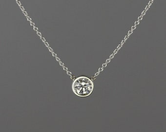 0.34 carat Diamond set in 18 kt white gold frame pendant with chain attached.