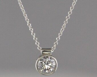 0.67 carat round Diamond set in 18 kt white gold bezel pendant with chain.