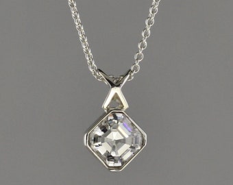 1.05 carat Asscher cut Diamond set in 18 kt white gold bezel set pendant.