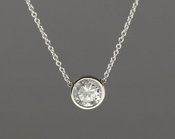 0.67 carat Diamond set in 18 kt white gold frame pendant with chain attached.