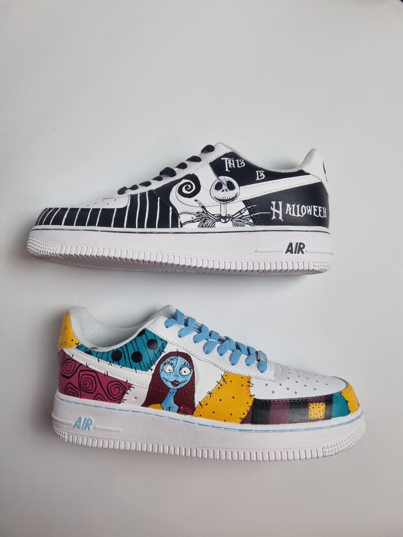 Puede incluir: Dos zapatillas pintadas a medida. Una presenta un dise&ntilde;o en blanco y negro con Jack Skellington y el texto "This is Halloween". La otra zapatilla tiene un dise&ntilde;o de patchwork con Sally de Pesadilla antes de Navidad.