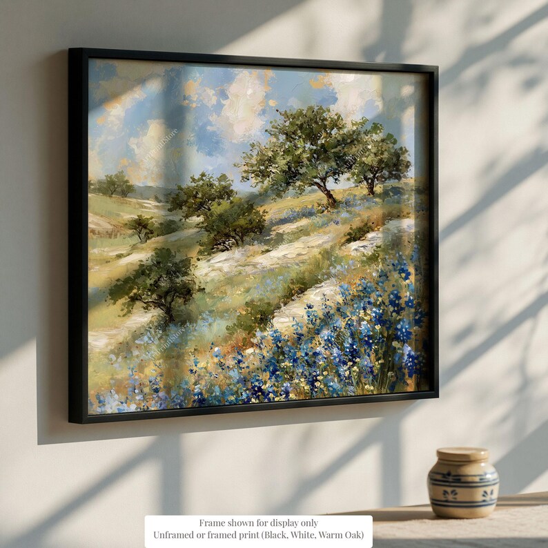 a framed painting of a scenic landscape with trees, flowers, and a blue sky.