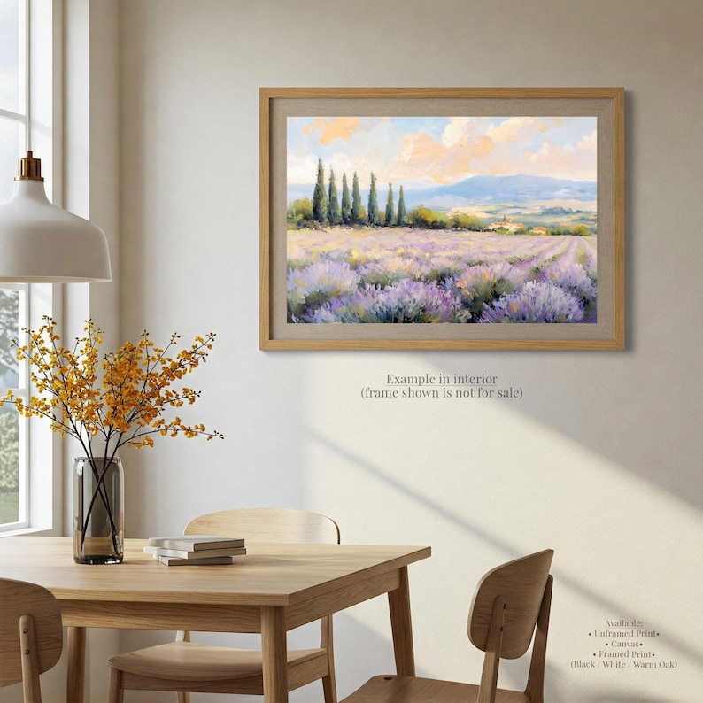 a serene indoor setting with a wooden table, chairs, and a framed painting of a field of purple flowers hanging on the wall.