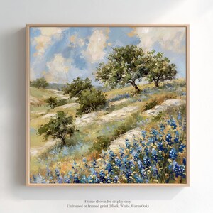 The image is a framed painting depicting a scenic landscape with a winding path, lush green trees, and a field of blue flowers.