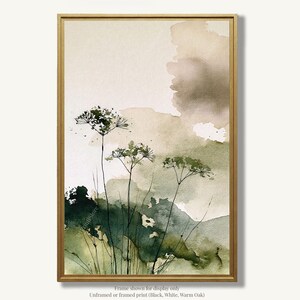 May include: A vertical rectangular wall art print in a thin gold frame featuring a watercolor painting of three delicate wildflowers with thin stems against a soft abstract background of blended sage green, olive, and beige washes.