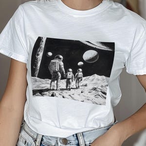 Outer Space Astronauts Unisex Softstyle T-Shirt, Astronomy Graphic Tee, Science Enthusiast Shirt, Spacewalk Astronaut Gift, Stars and Moons