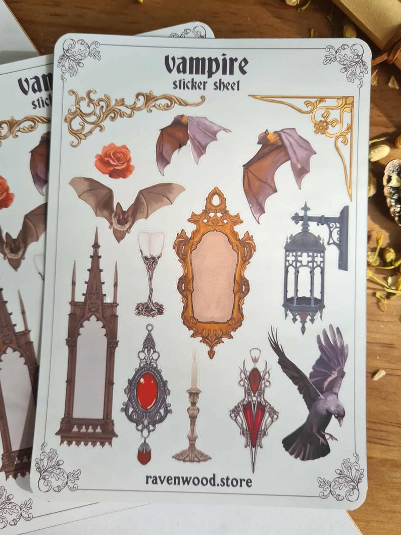 May include: A sticker sheet with a vampire theme. The sheet features illustrations of bats, a mirror, a raven, a rose, a goblet, and other gothic-style elements. The text "Vampire sticker sheet" is at the top. The website "ravenwood.store" is at the bottom.