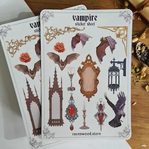 May include: Two sticker sheets with a vampire theme. The sheets feature illustrations of bats, roses, gothic architecture, mirrors, and a raven. The text "Vampire sticker sheet" is at the top. The website "ravenwood.store" is at the bottom.