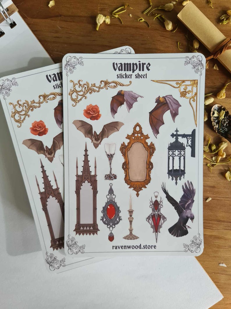 May include: Two sticker sheets with a vampire theme. The sheets feature illustrations of bats, roses, gothic architecture, mirrors, and a raven. The text "Vampire sticker sheet" is at the top. The website "ravenwood.store" is at the bottom.